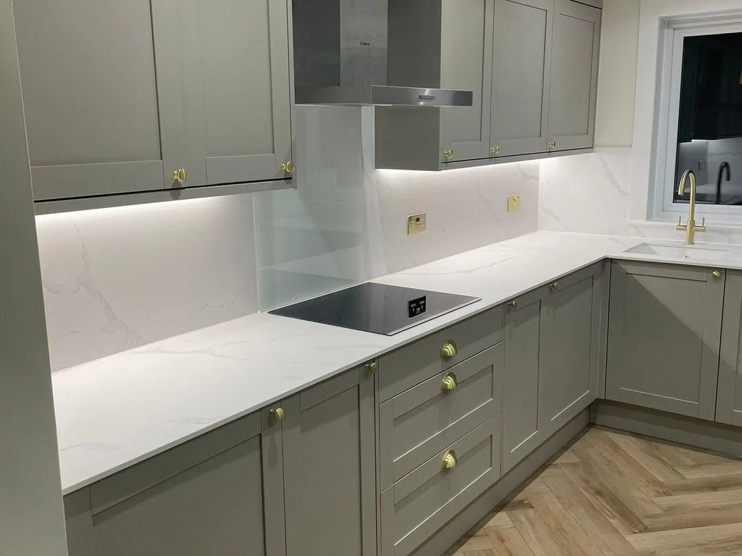 Grey fitted kitchen and joinery with brass details