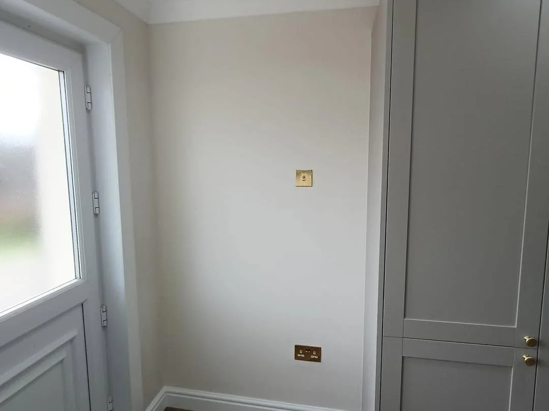 Finished wall and fitted cabinetry detail beside the kitchen entrance
