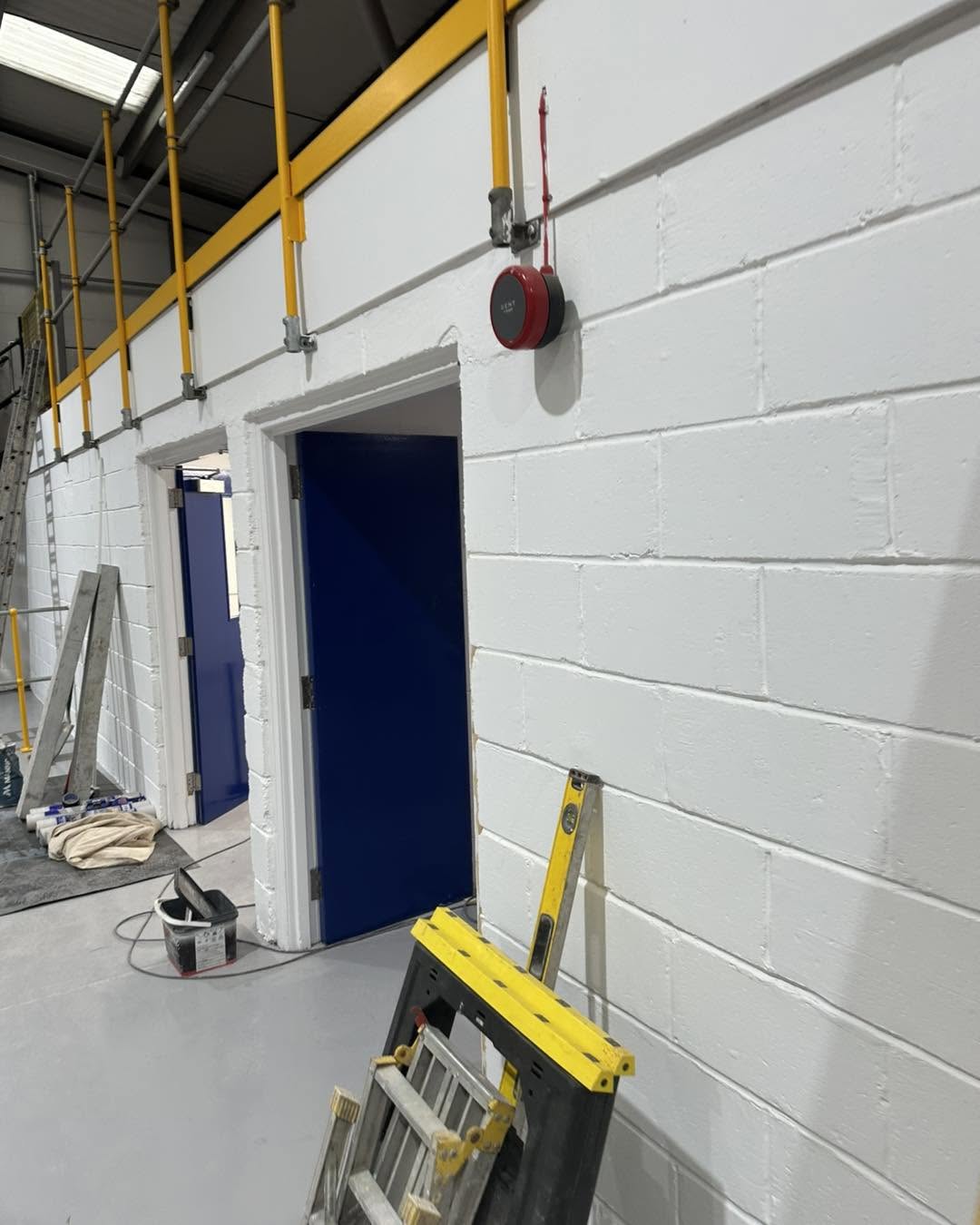 Painted blockwork and blue doorways during a commercial building fit-out