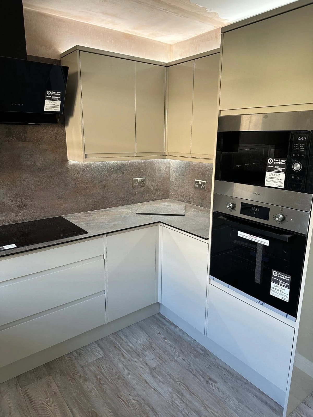 Integrated ovens, hob and illuminated corner cabinetry in the fitted kitchen