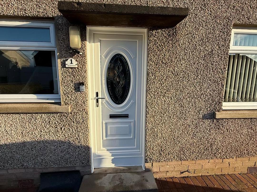 White external entrance door with decorative oval glazing and dark hardware